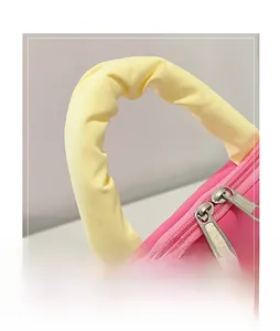 Detail of pink laptop bag featuring yellow ruched handles and durable silver dual zippers