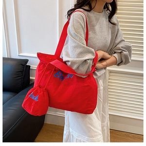 Détail du grand sac cabas en toile rouge avec broderie Beach et mini pochette assortie