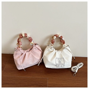 Detailed view of pink and white pleated handbags with gradient acrylic beaded handles