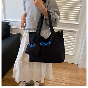 Détail du grand sac cabas en toile noire avec broderie Beach bleue et pochette