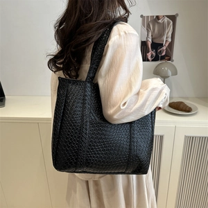 Minimalist black woven leather tote bag with large capacity for daily commuting wear
