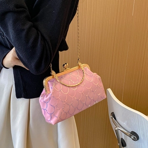 Pink sequin kiss-lock crossbody bag with gold chain and handle shown in a lifestyle setting