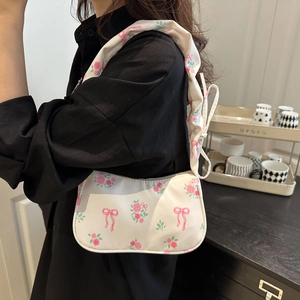 Macro shot of white pleated shoulder strap featuring pink rose and bow prints on fabric