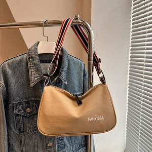 Dettaglio borsa tote in tela kaki con tracolla larga regolabile a righe rosso-bianco-blu
