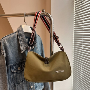 Dettaglio borsa tote in tela oliva con tracolla a righe e logo stampato FANYISSA