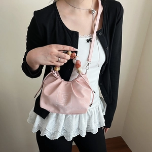 Pink pleated crossbody bag with colorful beaded handle and bear logo print design