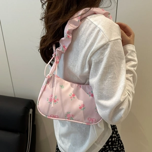 Floral shoulder bag with pink rose patterns and pleated ruffle strap on model