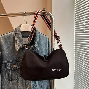 Dettaglio borsa a mezzaluna nera con logo FANYISSA e tracolla larga a righe colorate