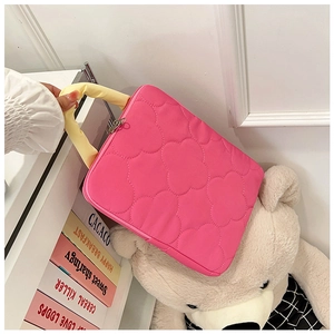 Close-up of pink quilted laptop bag featuring clover pattern and yellow fabric handles