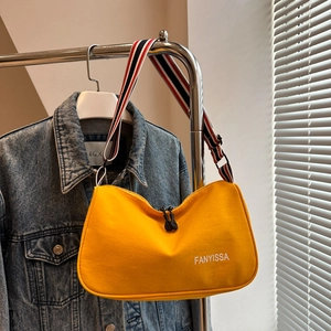 Dettaglio borsa hobo in tela gialla con tracolla a righe e logo FANYISSA stampato