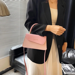 Pink crossbody handbag with leather and woven texture shown in a lifestyle setting