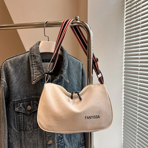 Dettaglio della borsa tote in tela bianca con ampia tracolla a righe e logo FANYISSA