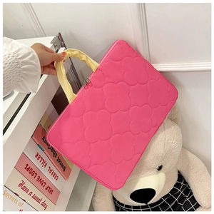 Detail of pink quilted laptop bag with petal patterns and yellow pleated handles