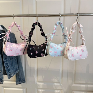 Detail of floral underarm bags in four colors with pleated straps and tassel accents