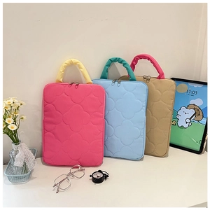 Detailed view of quilted laptop bags in pink, blue, and khaki with flower patterns