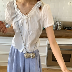 Sac à bandoulière créatif en forme de cacahuète argentée avec chaîne porté par un mannequin