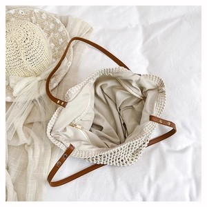 Detail of off-white woven tote with leather handles and spacious inner zip pocket