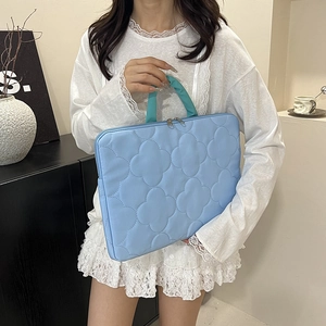 Quilted light blue laptop tote bag with teal handles and floral puff pattern