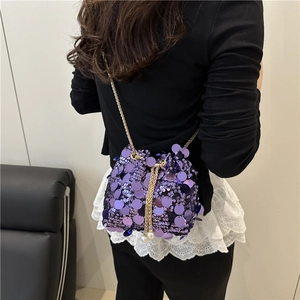 Detail of purple sequin bucket bag with pearl drawstring and golden chain strap