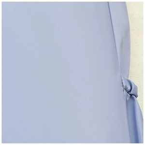 Detail of light blue woven fabric texture featuring a decorative knot design element