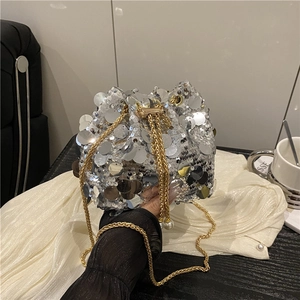 Detail of silver sequin bucket bag with gold chain strap and pearl drawstring tassels