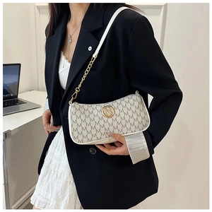 Detail of monogram print handbag with golden metal logo and chain shoulder strap