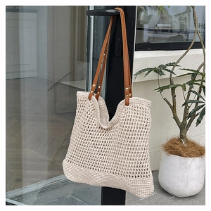 Detail of hollow woven tote bag with cream cotton mesh and brown leather strap