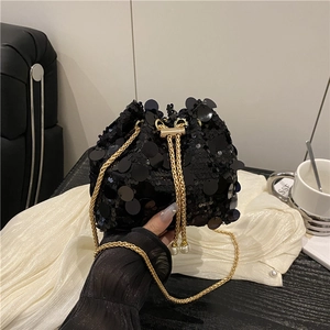 Detail of black sequin bucket bag featuring golden chain strap and pearl drawstring