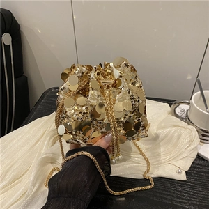 Detail of gold sequin bucket bag featuring pearl charms and a gold chain strap