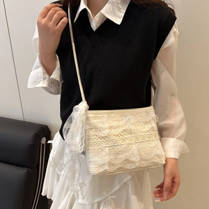 Close-up of white lace shoulder bag with tiered ruffles and a decorative bow detail