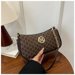 Detailed macro view of retro brown monogram print bag with gold circular M metal logo
