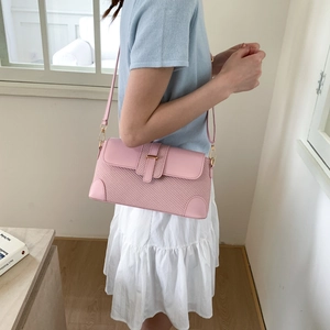 Détail du sac à bandoulière en texture tissée rose avec boucle métal et sangle en cuir