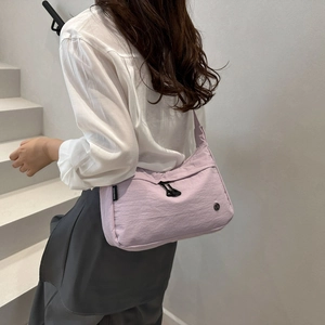 Detail of light purple nylon tote bag featuring black zipper and FANYISSA side tag
