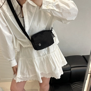 Sac cylindre noir minimaliste avec large bandoulière et logo M argenté chic