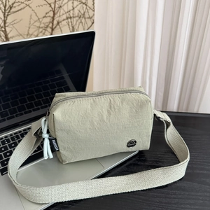 Dettaglio della trama della borsa a tracolla in nylon verde salvia con logo in metallo