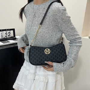Chic black underarm bag with M letter pattern and gold logo in a stylish lifestyle scene