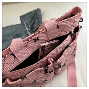 Dettaglio della borsa tote in velluto rosa con tasche a zip e stampa a fiocco nero