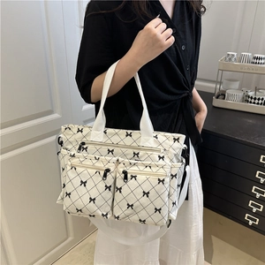 Borsa tote minimalista in velluto beige con motivo a fiocchi neri e tasche funzionali