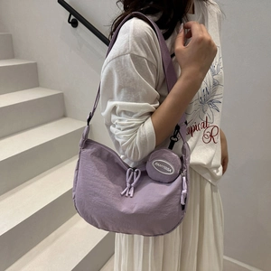 Sac bandoulière minimaliste en nylon lilas avec une petite pochette ronde assortie