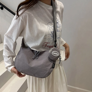 Detail of dark grey nylon crescent bag with adjustable strap and detachable round pouch