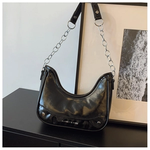 Detail der schwarzen glänzenden Hobo-Tasche mit Silberkette und Metallnieten
