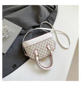 Detail of white leather shell bag with vintage brown monogram print and red edge finish