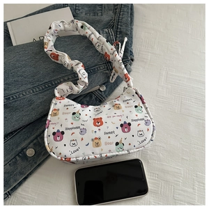 Detail of white underarm bag with colorful bear prints and ruffled cloud shoulder strap