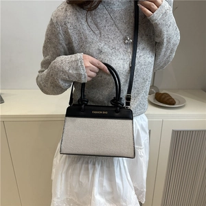 Two-tone fashion handbag with leather stitching and adjustable crossbody strap for women