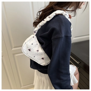 Detail view of white underarm bag featuring cartoon bear print and ruched strap design