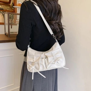White glossy PU shoulder bag featuring pleated design and dual ribbon bow pockets