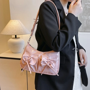 Pink glossy faux leather underarm bag with decorative bows and front double pockets