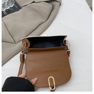 Detalle del bolso bandolera de tweed mostrando interior espacioso y cierre dorado de imán
