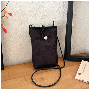 Detail of black silk mobile phone bag with pine pattern and camellia pearl drawstring
