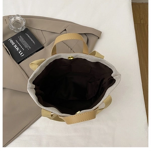 Vista superior de bolso tote de lona con detalles de cuero y cierre magnético